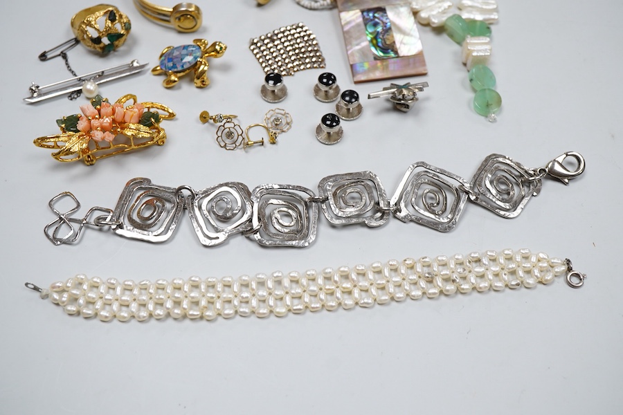 A collection of costume jewels, comprising: a floral coral and nephrite brooch; a composite opal triplet brooch designed as a turtle; a textured gilt metal ring set with hardstone fragments; a cultured pearl and chrysopr